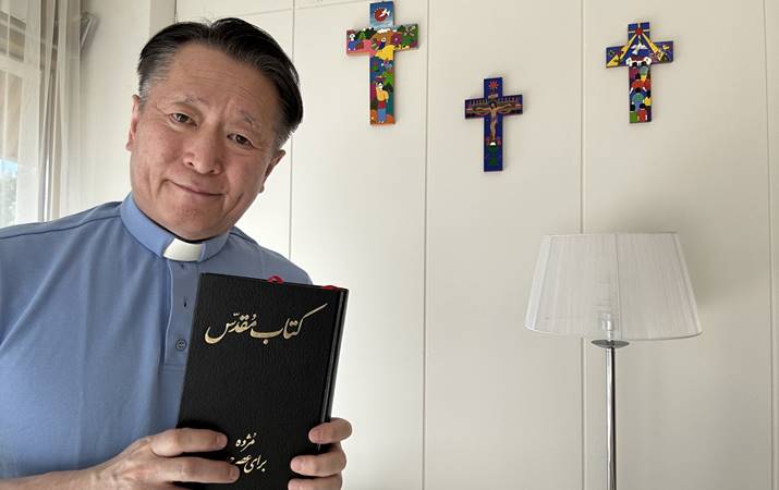 Sr. Toshiki með Biblíuna á farsi